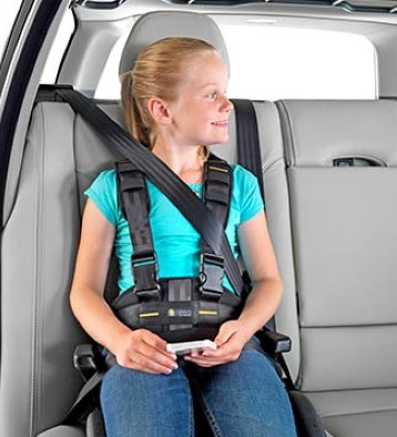 Girl sitting in a car with a posture belt strapped on
