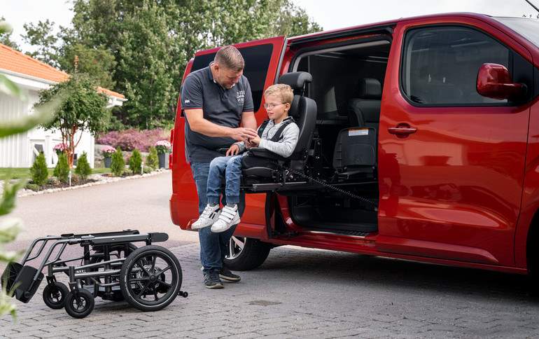 Man assisting a child into a turnign seat
