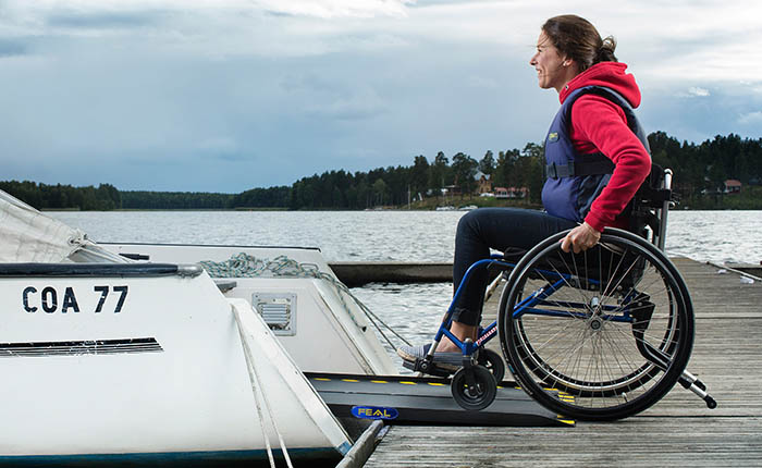 Woman in a wheelchair in a ramp rolling into a boat