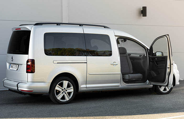 A full view of a Volkswagen Caddy with the front passenger door open. The front passenger seat is rotated towards the viewer.