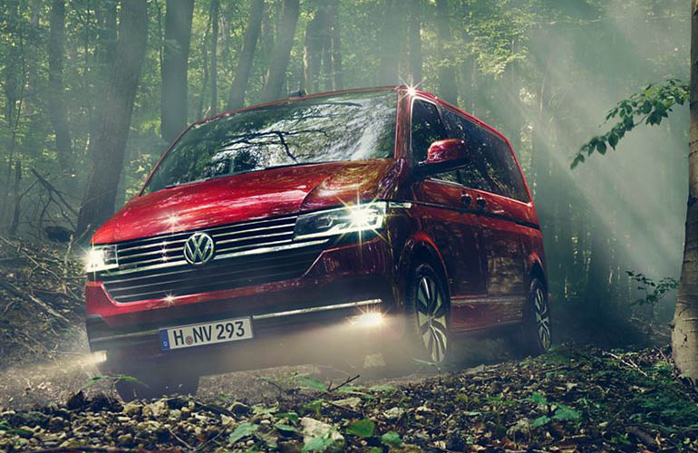 Red Volkswagen multivan in a forest
