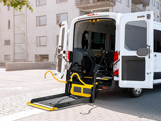 A van with open rear doors and a deployed wheelchair lift. 
