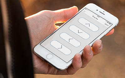 Hand hält ein Smartphone mit der BraunAbility App