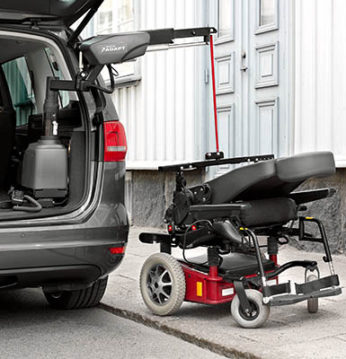 A powerchair ready to be loaded into a car using a hoist.