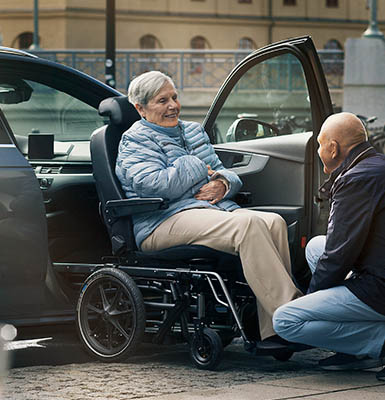 An elderly couple using a transfer wheelchair.